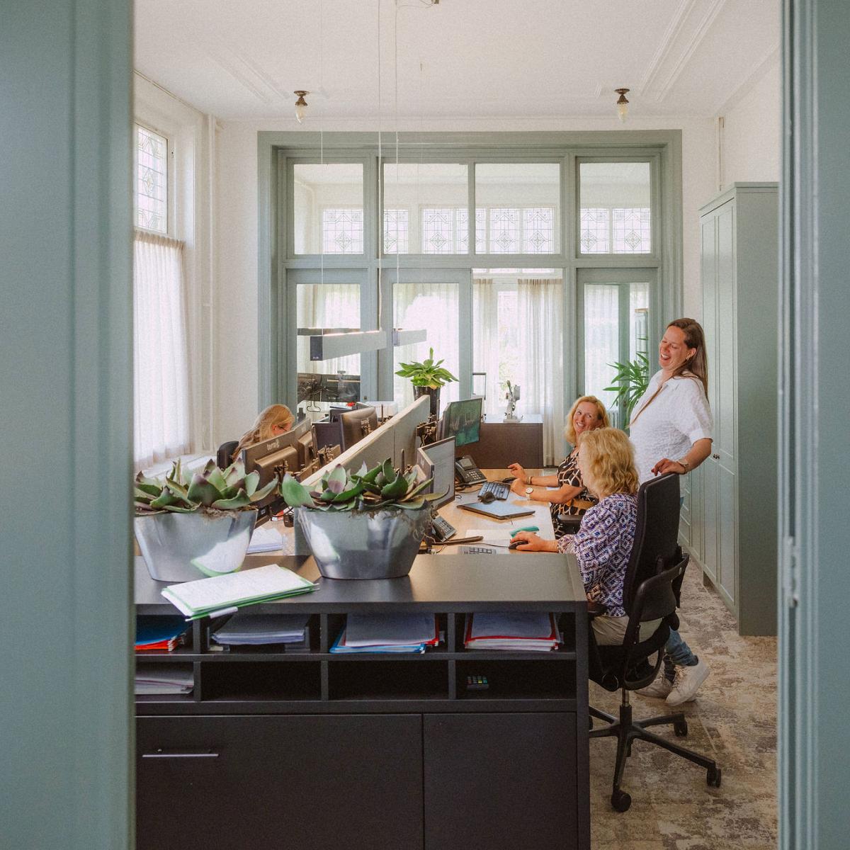 Vooraanzicht van het bedrijfspand van Notariskantoor Voorhout met op de voorgrond bomen. 